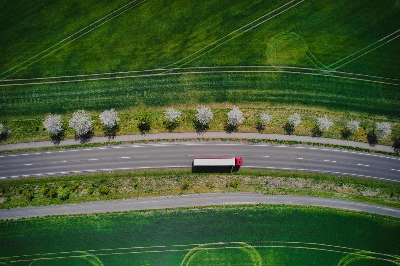 ORLEN zrównoważony rozwój i OZE. Ciężarówka poruszająca się na drodze szybkiego ruchu, z otaczającą zielenią, która symbolizuje zrównoważony rozwój w transporcie i troskę o środowisko.